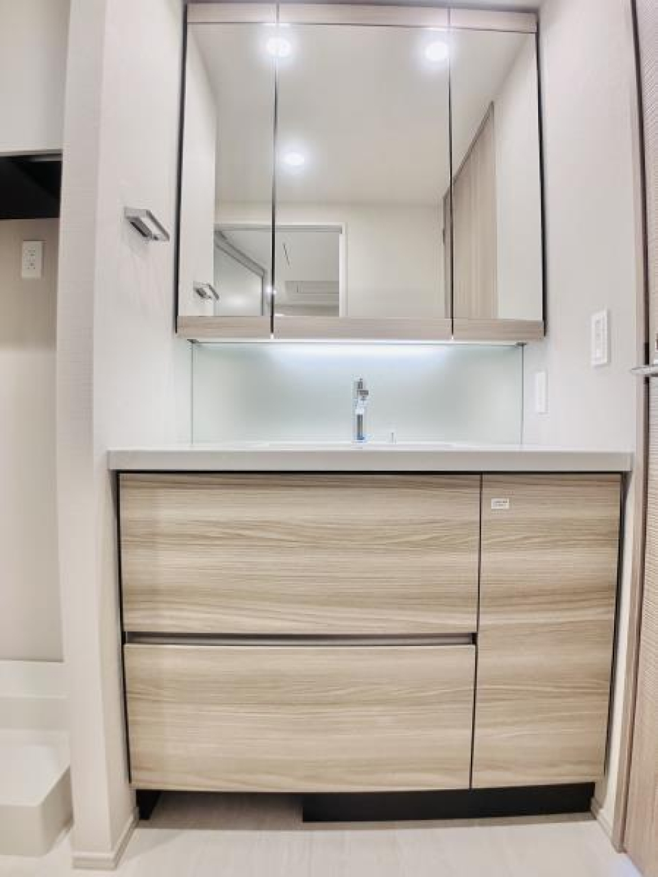 鏡が大きな、清潔感のある洗面台。収納もたっぷり入りそうです。