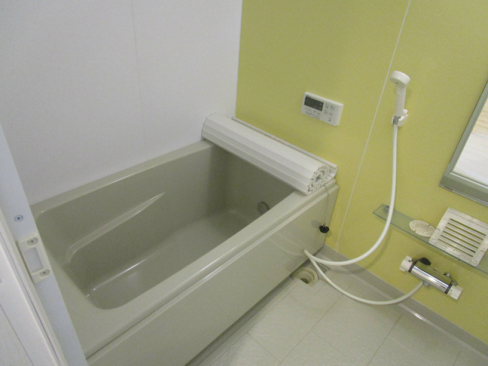 ライトグリーンの壁紙がアクセントの浴室