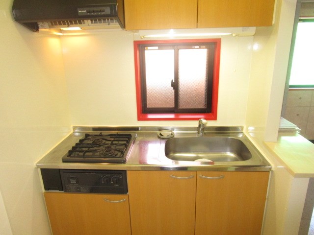 リビングとテイストの違うキッチン。こちらも赤い窓枠がアクセント。カウンターも付いています。