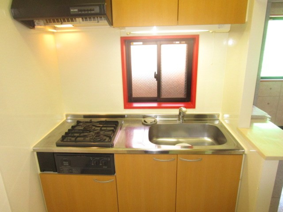 リビングとテイストの違うキッチン。こちらも赤い窓枠がアクセント。カウンターも付いています。