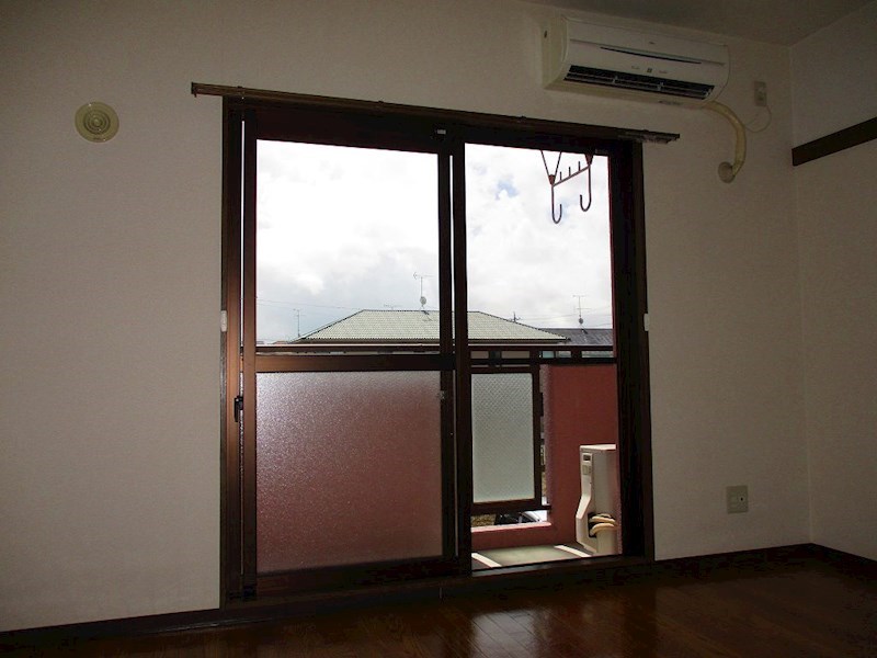 窓ガラスからは日光と共にベランダのピンク色が差し込みます。