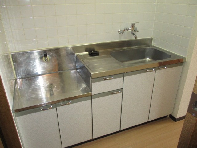 壁は白タイル張りのキッチン。収納も付いています。