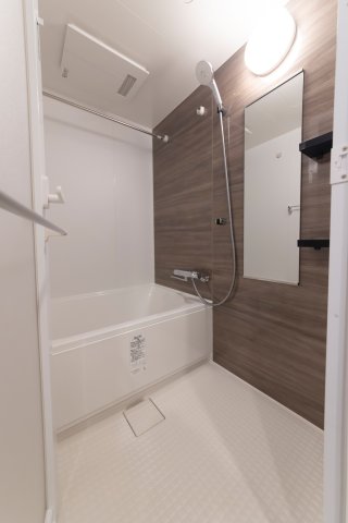 ブラウンのナチュラルなパネルが導入された浴室です。