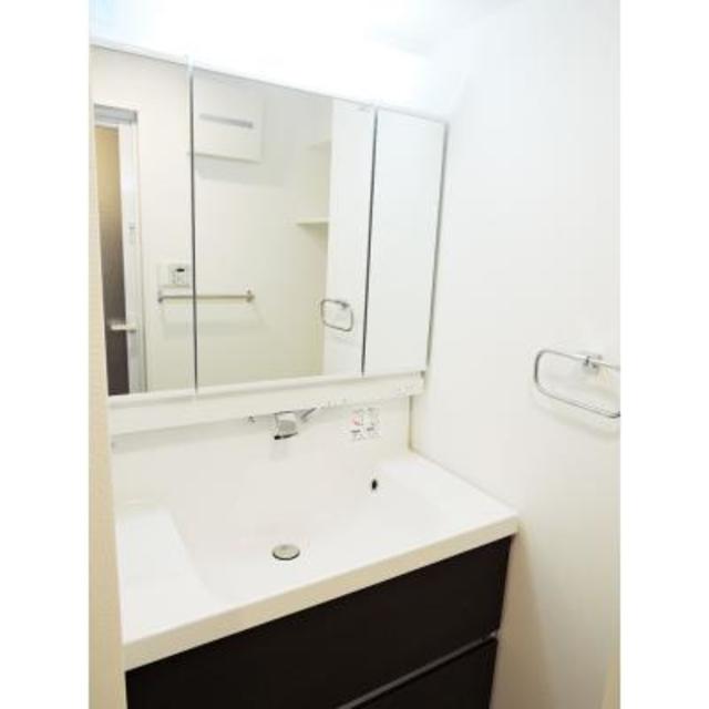 ダークトーンのパネルが設置されている洗面台です。※写真は同タイプ住戸です。