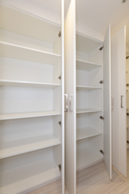 廊下の壁一面にはたっぷりの扉付き収納。日用品のストックができて便利です。※写真は同タイプ住戸です。