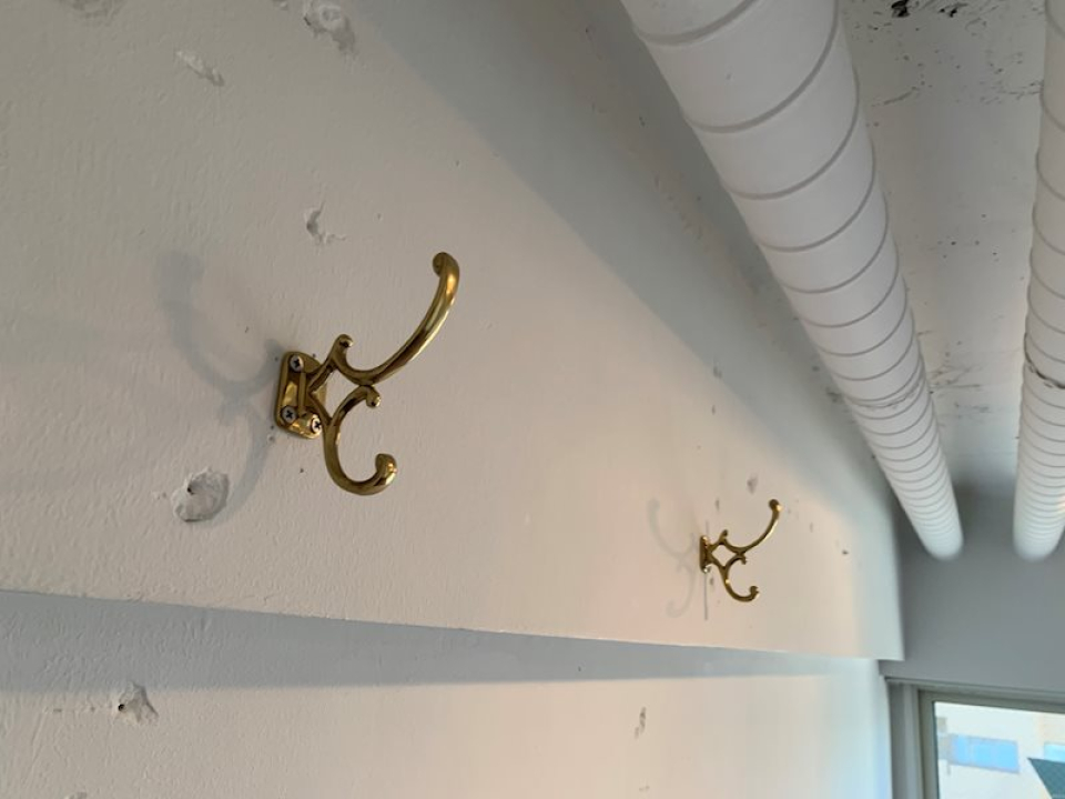 ドアノブや壁のフックなど、散りばめられた真鍮アクセサリー。優雅な都会暮らしを演出しています。