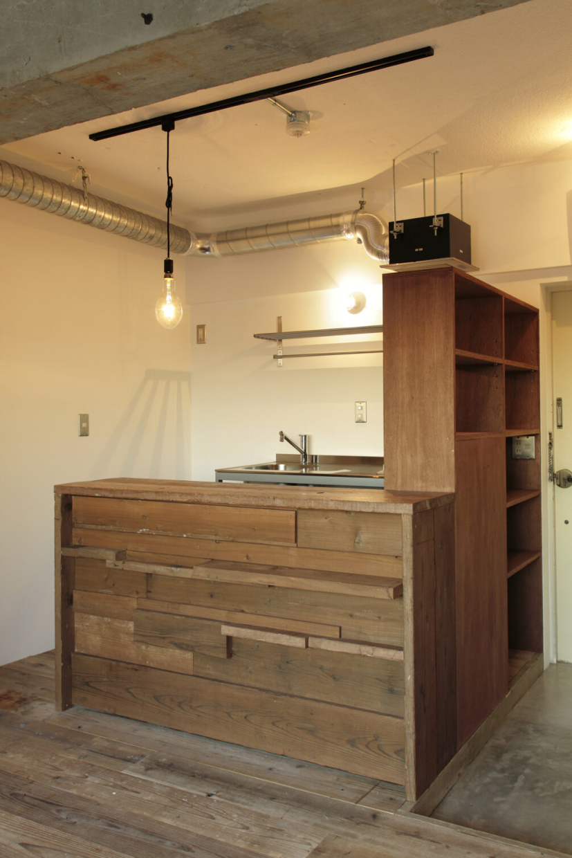 ランダムに貼られた足場板がラフな印象のカフェカウンター。