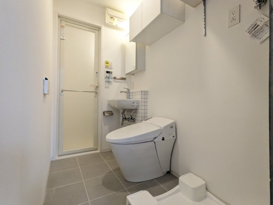 洗面台、洗濯機、トイレが同じ空間に設置されています。