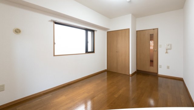 ブラウンの木目のフローリングに、シンプルな白い壁の内装です。