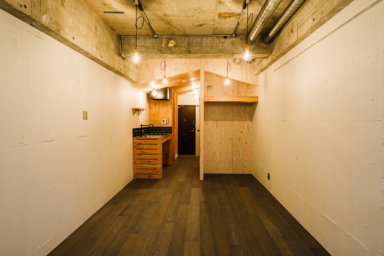 キッチンスペースと居室の境には、木目がユニークなラーチ材でつくられた、小屋のような三角屋根がお目見え。