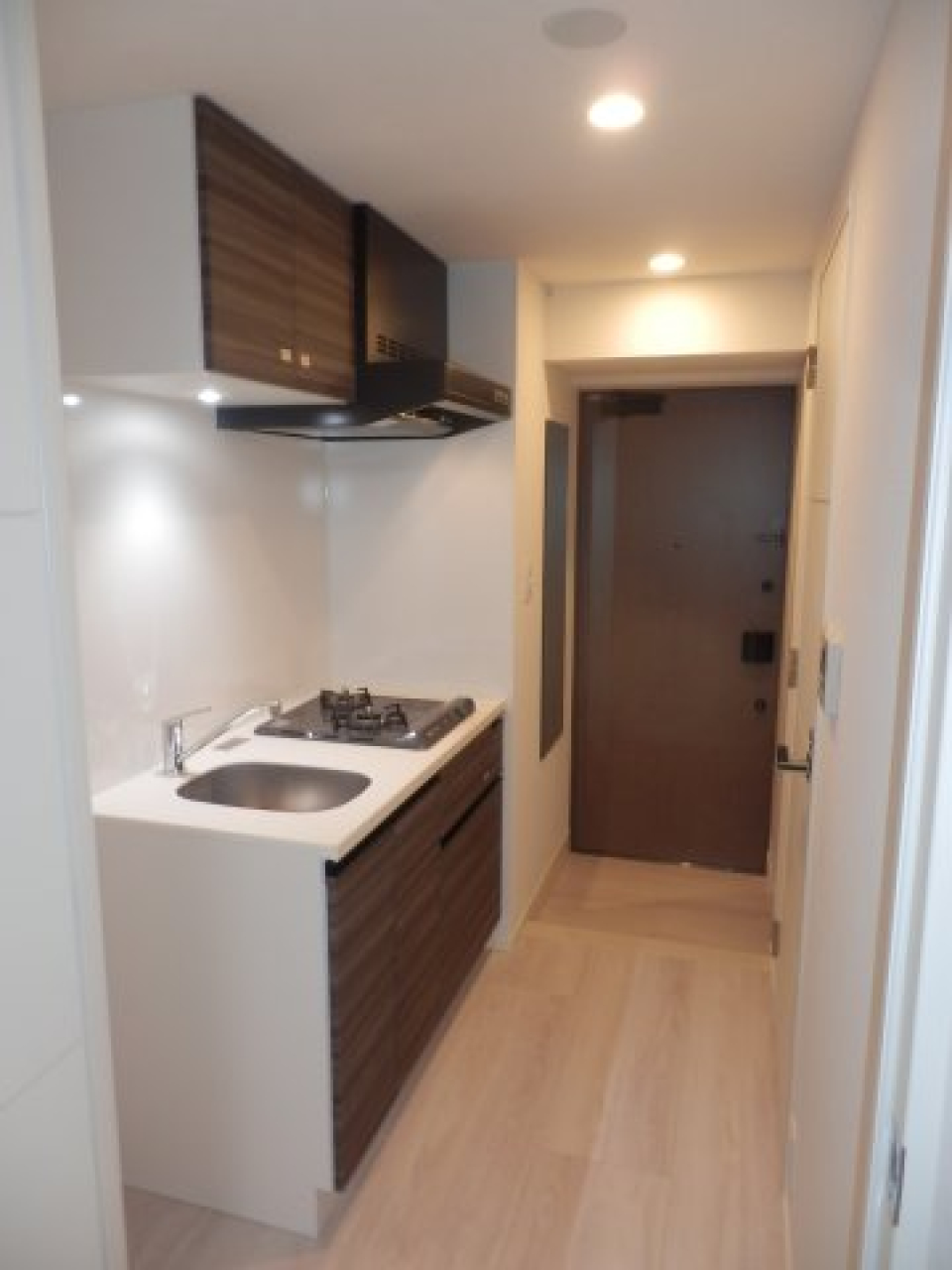 ２口のガスコンロが設置されています。ブラウンの落ち着いたパネルが採用されています。