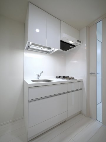 ２口のガスコンロが設置されています。頭上にも収納があってワークスペースを上手く取り入れたいところです。