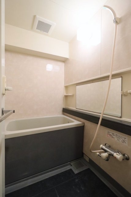 横に幅が広い鏡が設置された浴室です。