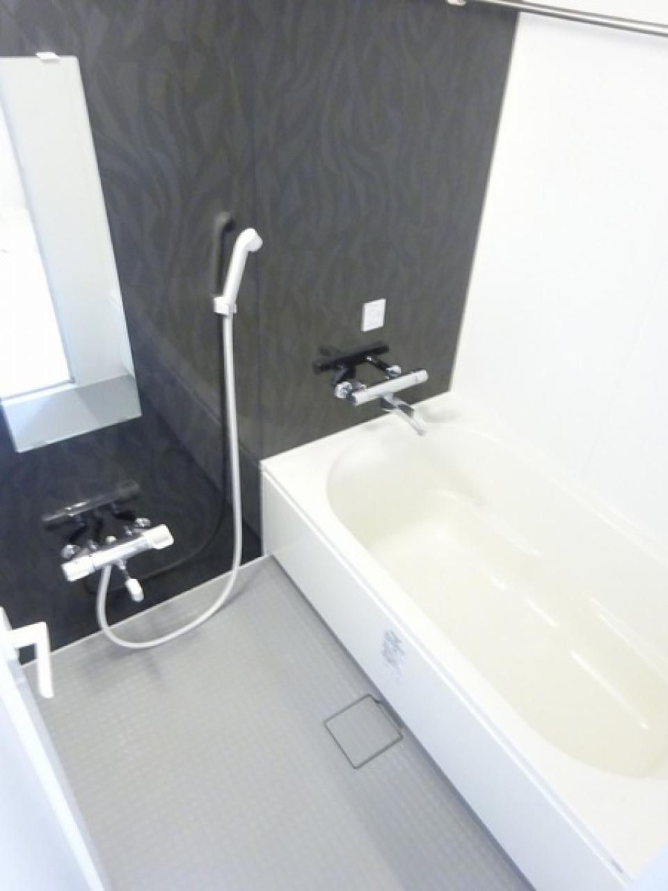 ダークトーンのパネルが採用された浴室。