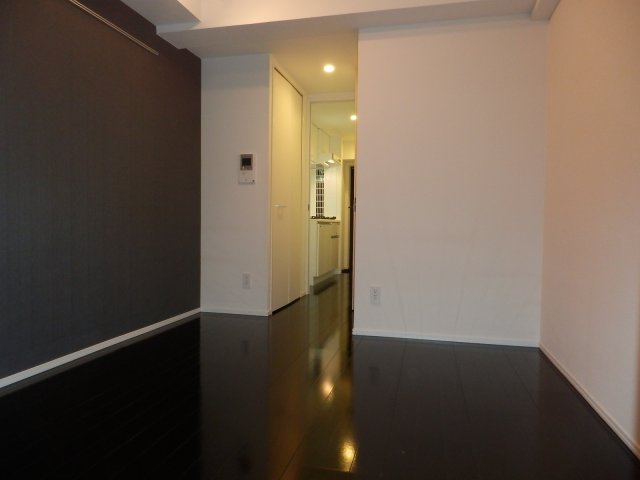 ダークトーンのフロアと白い壁紙のモノクロの洋室です。