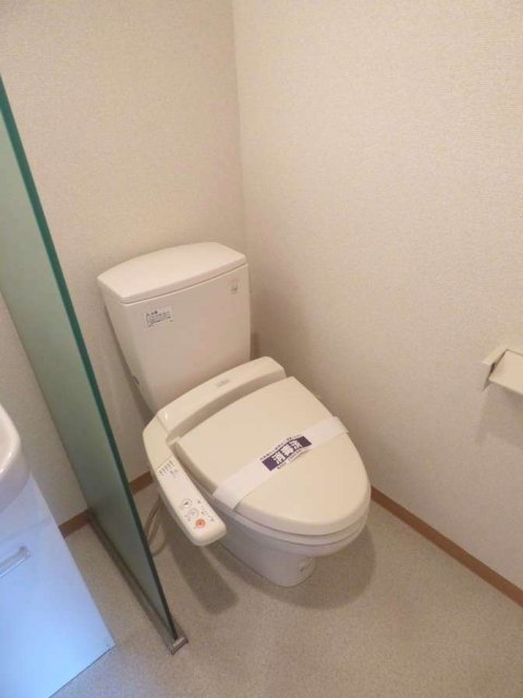 洗面台横のガラスを隔ててトイレがあります。