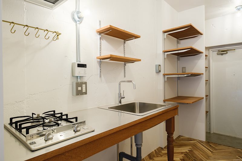 フックと可動棚が備え付けの、スタイリッシュなキッチン。