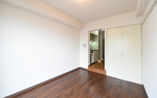 落ち着いたブラウンのフローリングに白い壁紙のシンプルなお部屋です。