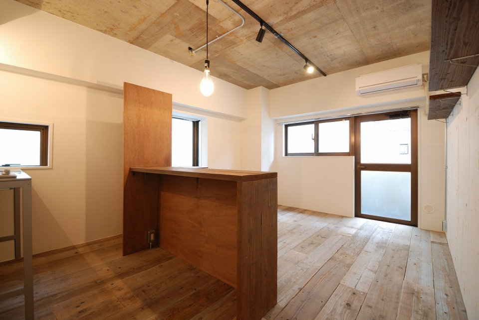 味わい深いカウンターと剥き出しのコンクリート、大きめのイカ釣り電球がムードを演出してくれている。