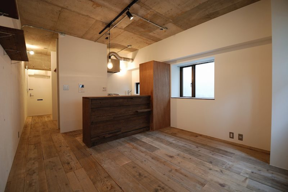 職人さんの手によってランダムに貼られた足場板が、ラフな印象のカウンター。