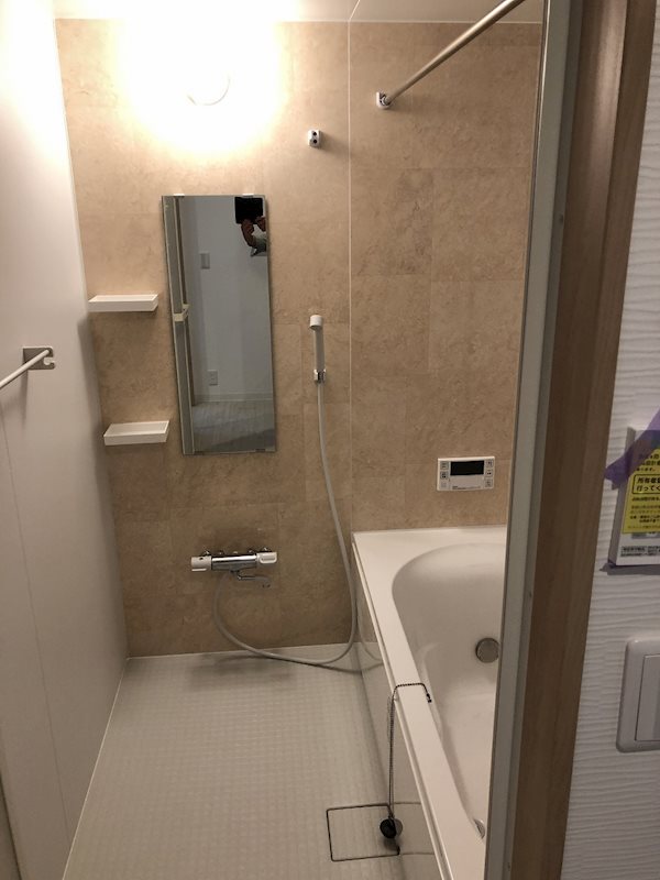 大理石風な壁と大きな浴槽のお風呂。ホテルライクな雰囲気で優雅なバスタイムになります。突っ張り棒もあるので、シャワーカーテンや室内干しに便利です。鏡と棚付きもありがたい！