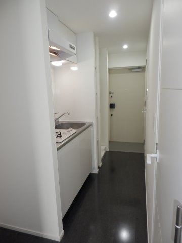 廊下にある真っ白なキッチン、2口のガスコンロまで真っ白。