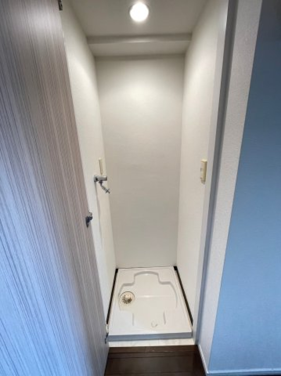 扉で隠された洗濯機置き場は暗くならないようにスポットライトがついています。