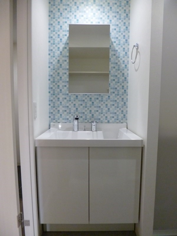 水色のタイルがアクセントの洗面台