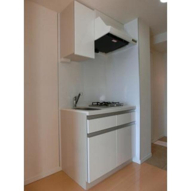 キッチンはインテリアを邪魔しない白。２口コンロのシステムキッチンです。
※写真は同タイプ住戸です。