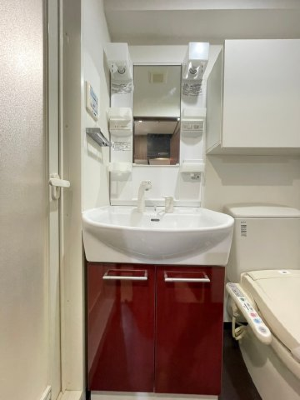 レッド系のワンポイントカラーが映える独立洗面台。
