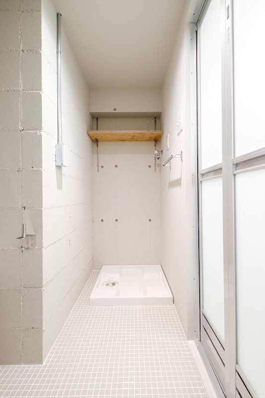 洗濯機置き場には簡易棚付き。洗濯籠やワゴンを置いて使い勝手をよくしたい。