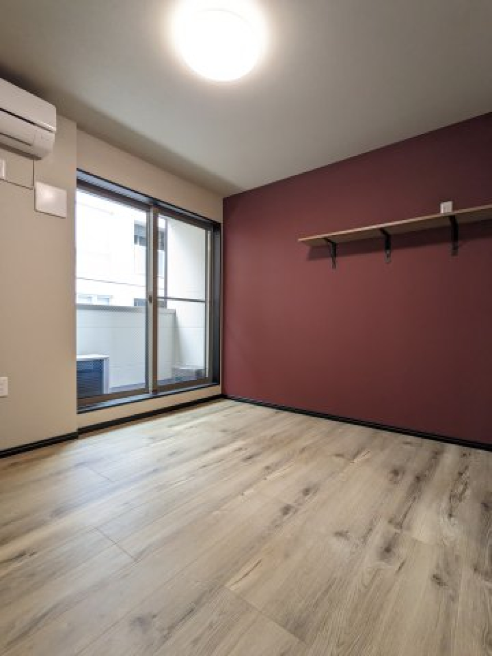 赤みがかったブラウンで気品溢れる1Kに。5.7帖の居室は、アクセントウォールが主役です。