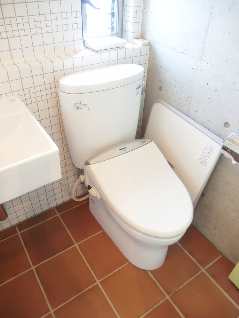 サニタリースペースは別フロアにひとまとめ。床の赤茶タイルと壁の白タイルがヴィンテージ感。