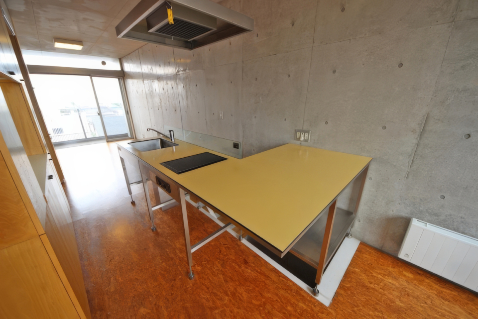 階段の手すりに沿ってL字のキッチン。部屋の中心なのでこまめに掃除したい。