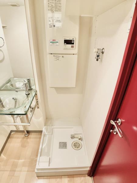室内洗濯機置き場です。ちらっと見える洗面所の扉も赤色ですね。赤のアクセントが暮らしを華やかにしてくれそう。