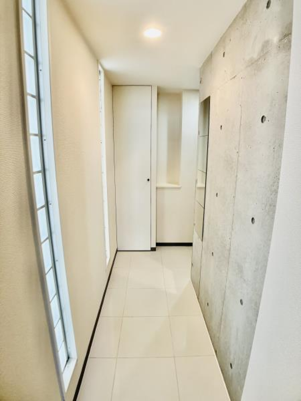 玄関まで続くコンクリ素材。ガラスブロックがアクセントになり、カッコいい！