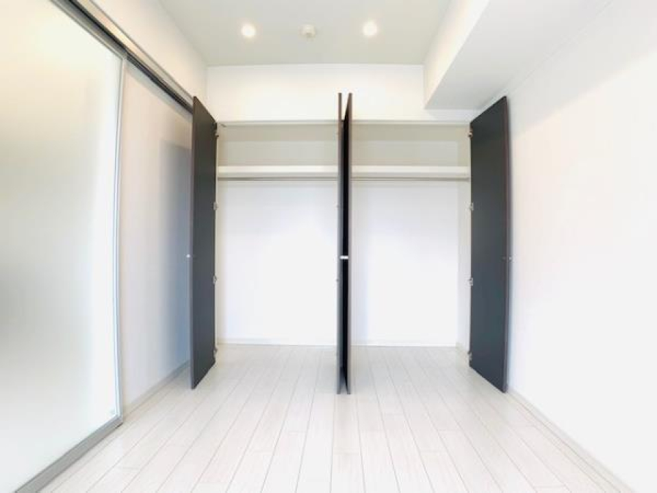 洋室の壁いっぱいのクローゼット。シーズンオフのお洋服や普段使わない旅行用のバッグなどは上段に。