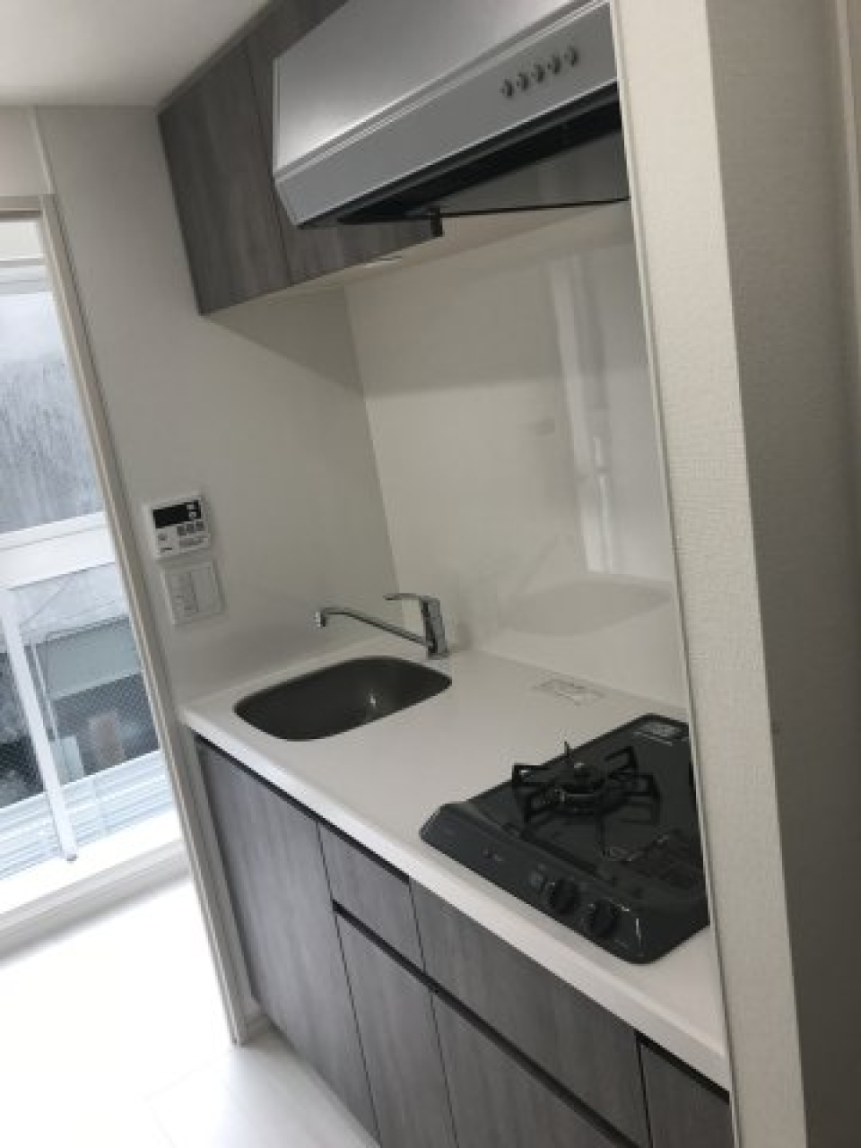 ２口コンロのシステムキッチン。コンロが黒いと、汚れが目立ちにくいのがいいところ。