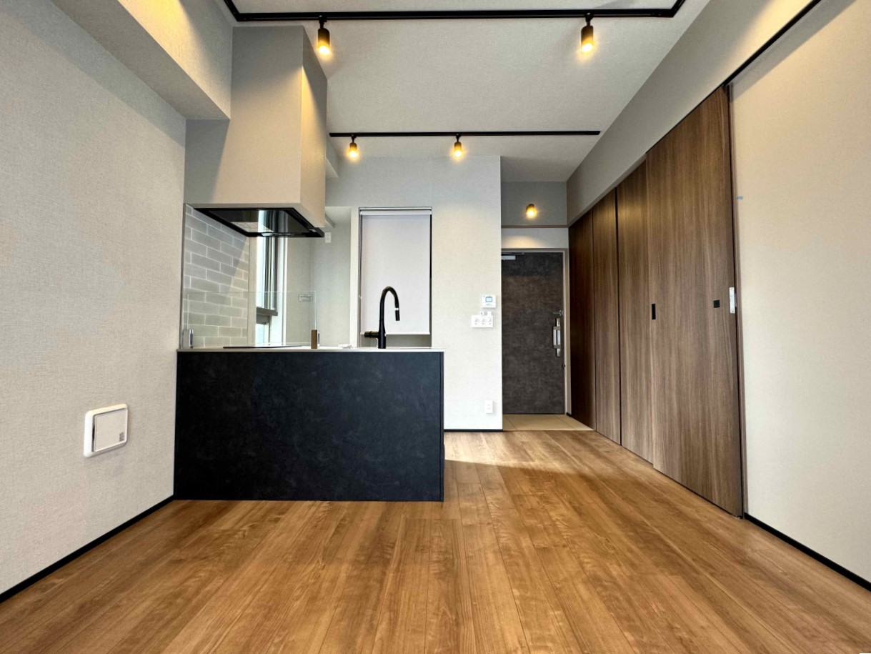 ブラックの対面キッチンとブラウンの床材の雰囲気がgood