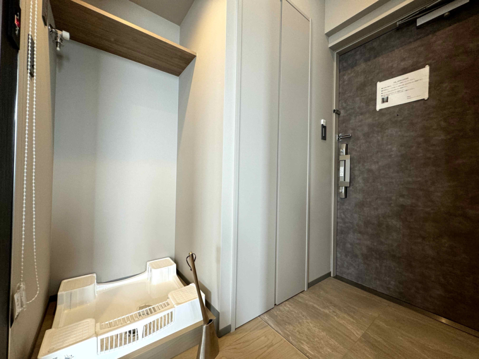 玄関先に洗濯機置き場。ロールスクリーンで隠すことができる。