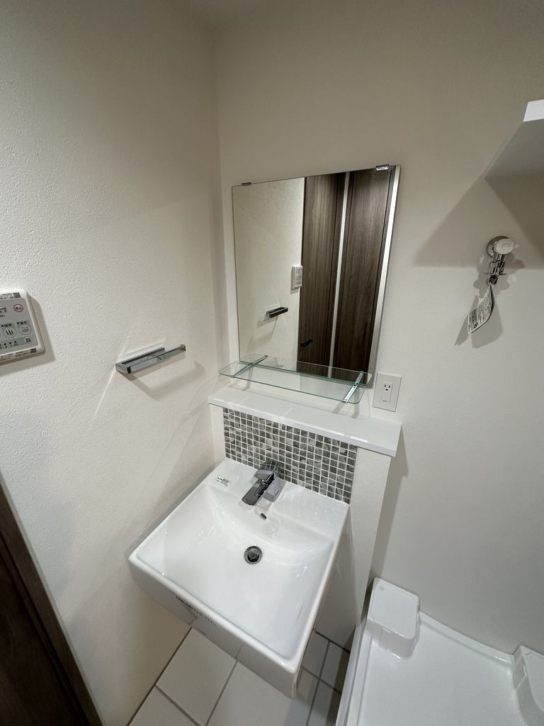 洗面台は無駄のないスタイリッシュなデザインです。横に室内洗濯機置き場があります。