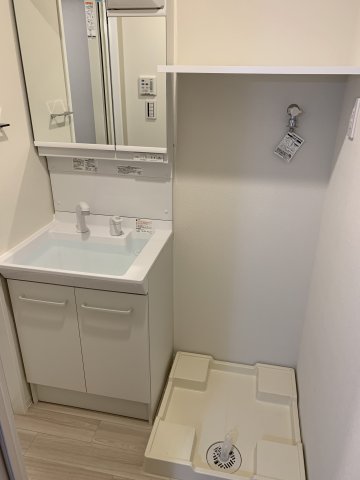 洗面台はシャワー付き。浴室洗濯機置き場の上には棚があるので整理整頓に役立ちます。