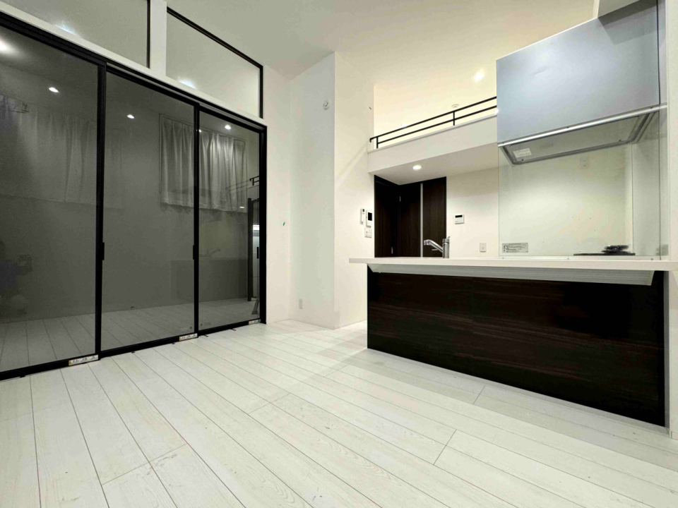 スモークガラスの3本引き引戸で部屋を仕切れるし、開放して1部屋として利用できる。