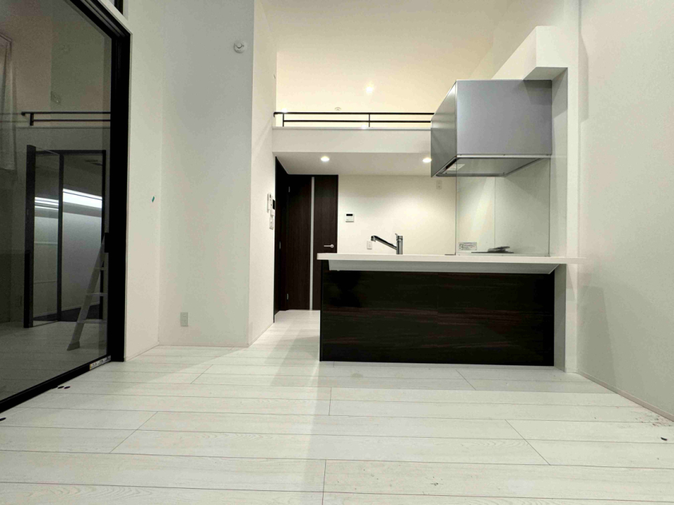 白い床と黒いキッチンのコントラストが素敵