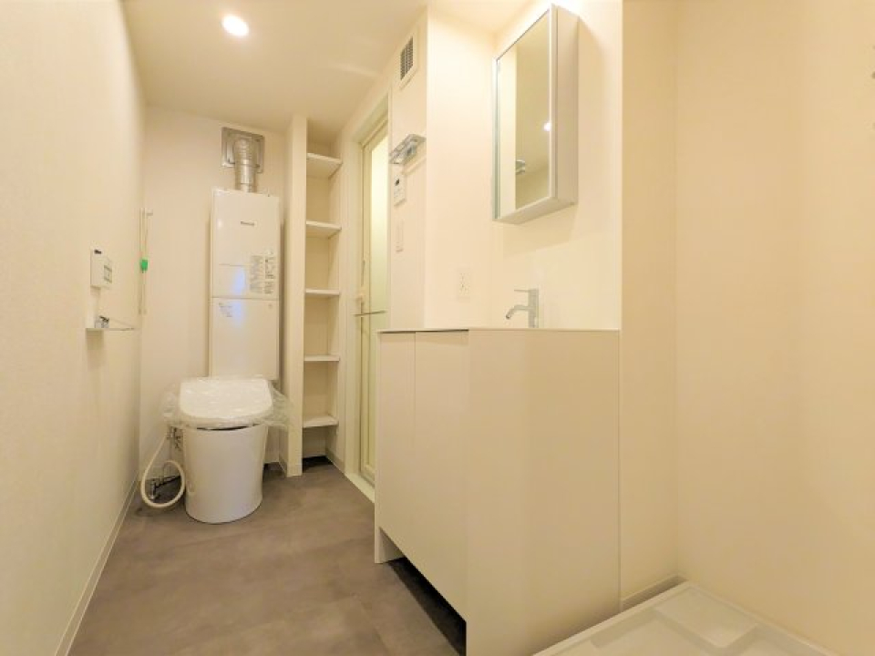 独立洗面台と、トイレは同じ空間に設置されています。鏡の裏にも収納できます。