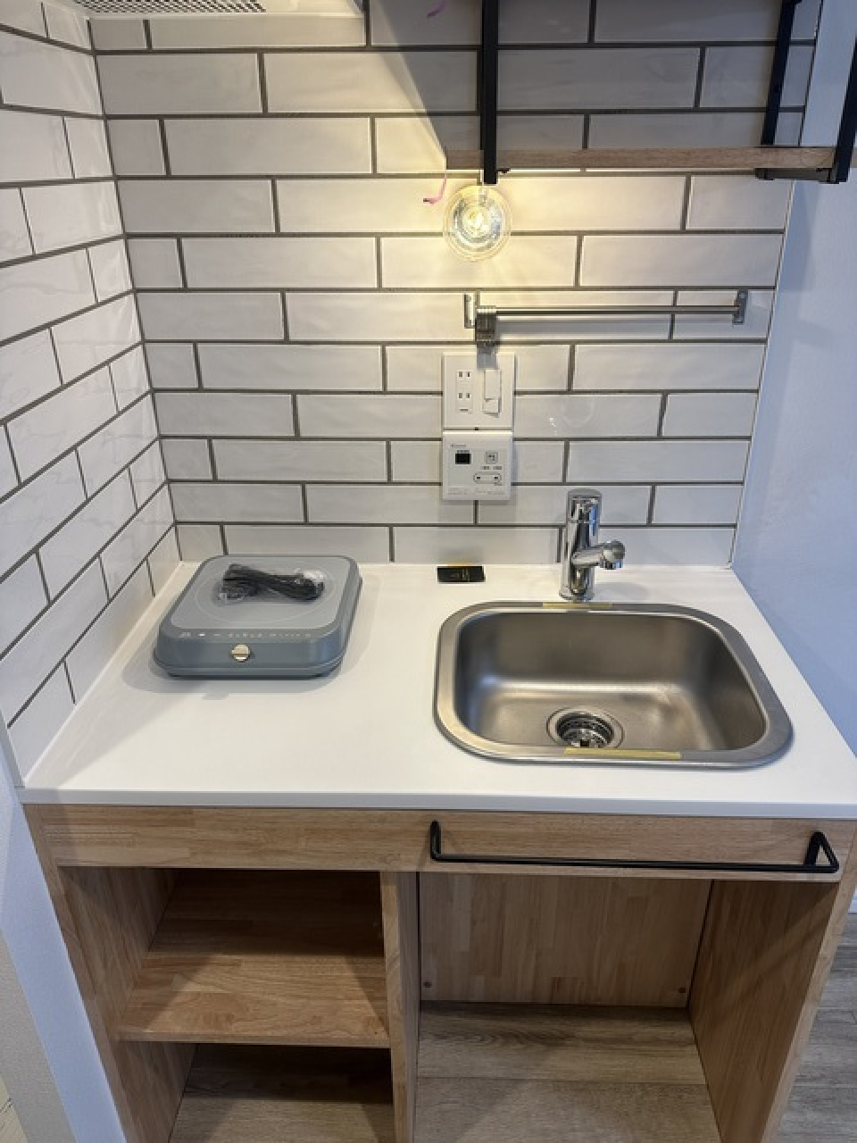 白いタイルと木製のキッチンがかわいい