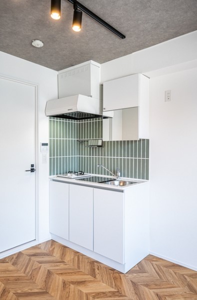 グリーンの壁が特徴的なキッチン。お部屋のかわいいアクセントに。