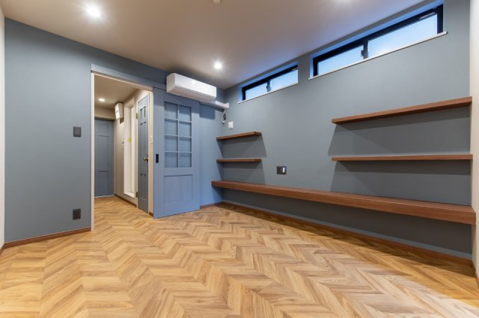 スモーキーなブルーとヘリンボーン、備え付けの木棚、扉まで。細部にこだわったデザイナーズアパート