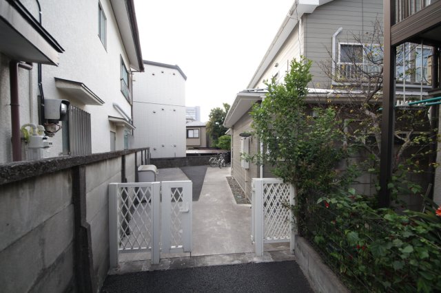 長いエントランス。自転車置場や敷地内にゴミの集積所があるので、便利です。 