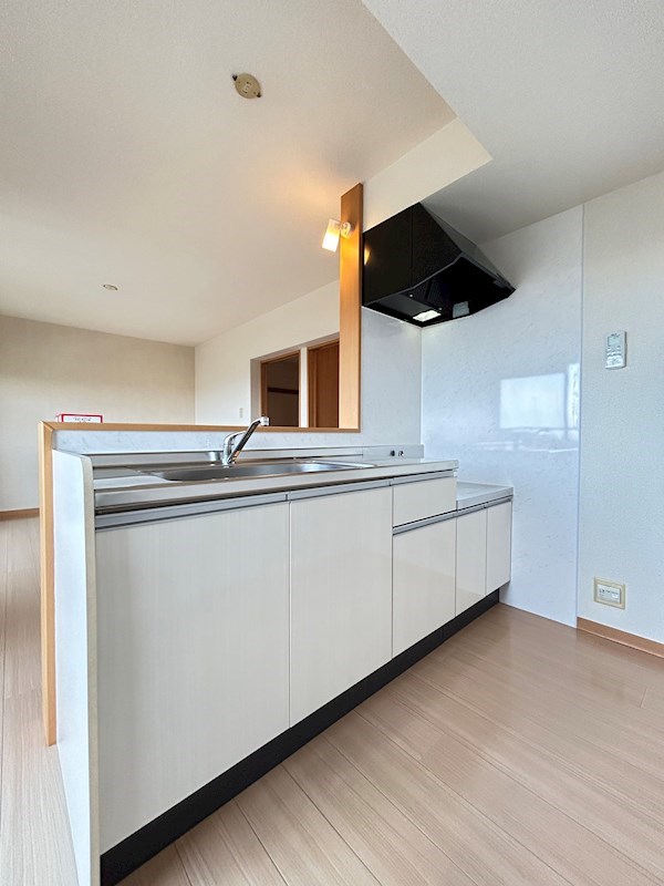 白でまとめられた対面式キッチン広々使えます